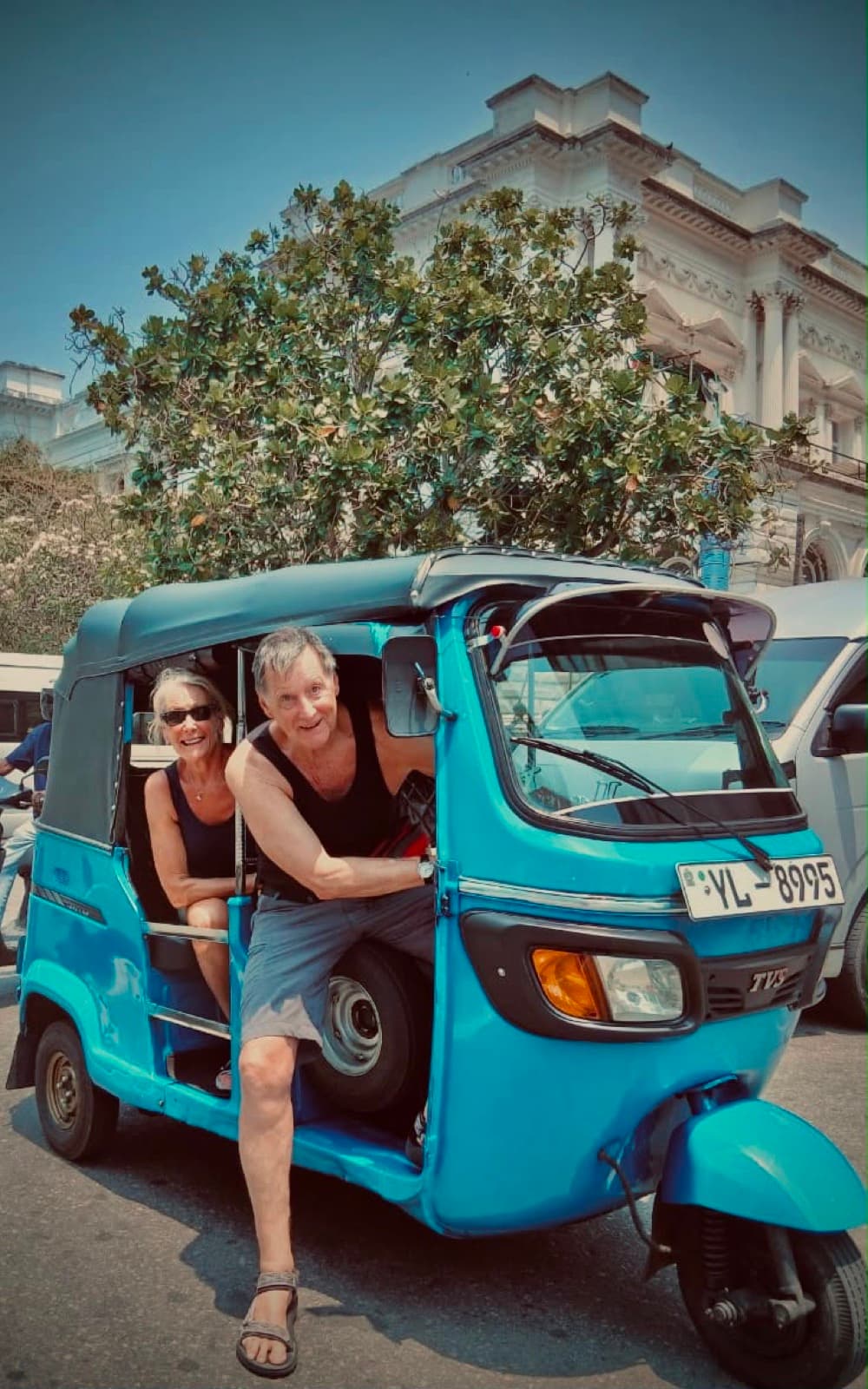 Couple climbing into David's blue tuk-tuk