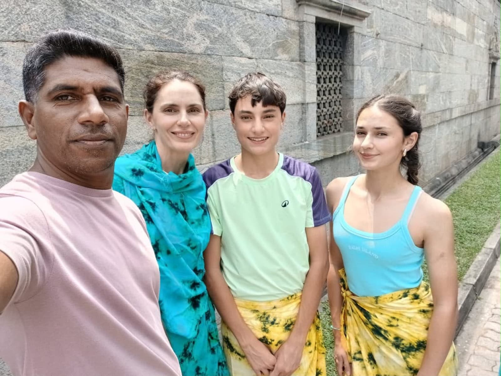 David's selfie with a family by a granite temple wall