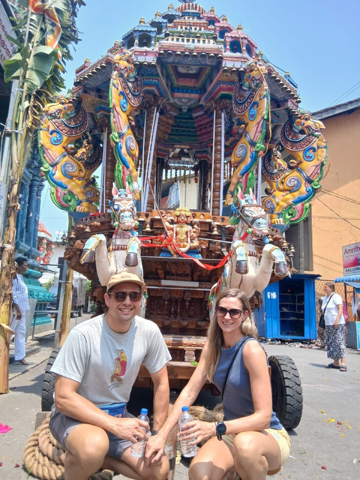 Couple beside an ornate Hindu temple chariot